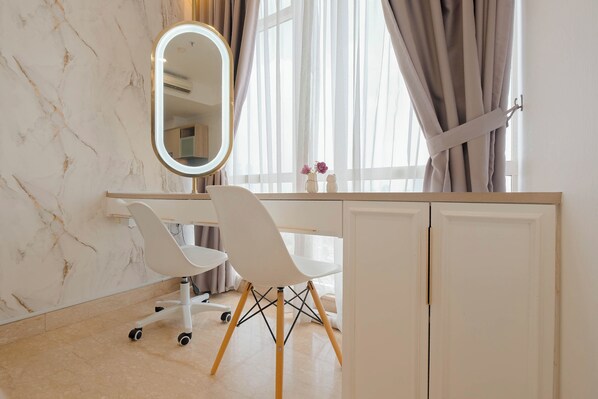 A modern bathroom with a marble wall, a white vanity with a mirror, a white chair, and a window with curtains. - Best Location And Homey Studio At Menteng Park Apartment (Jakarta)
