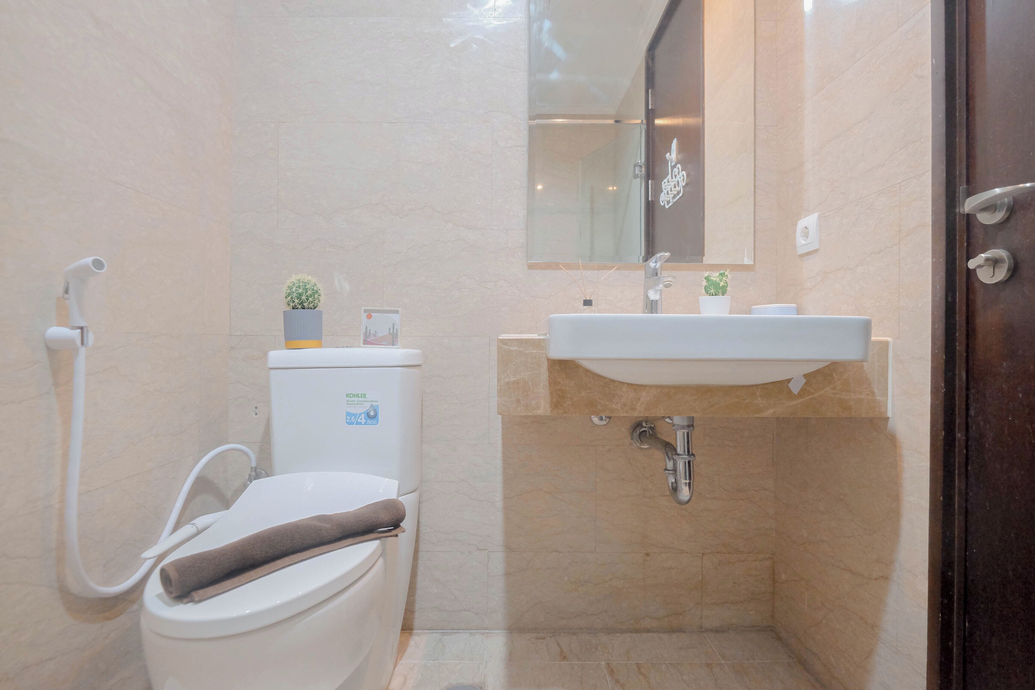 Un bagno moderno con servizi igienici, bidet, lavabo e specchio sopra il lavabo.
