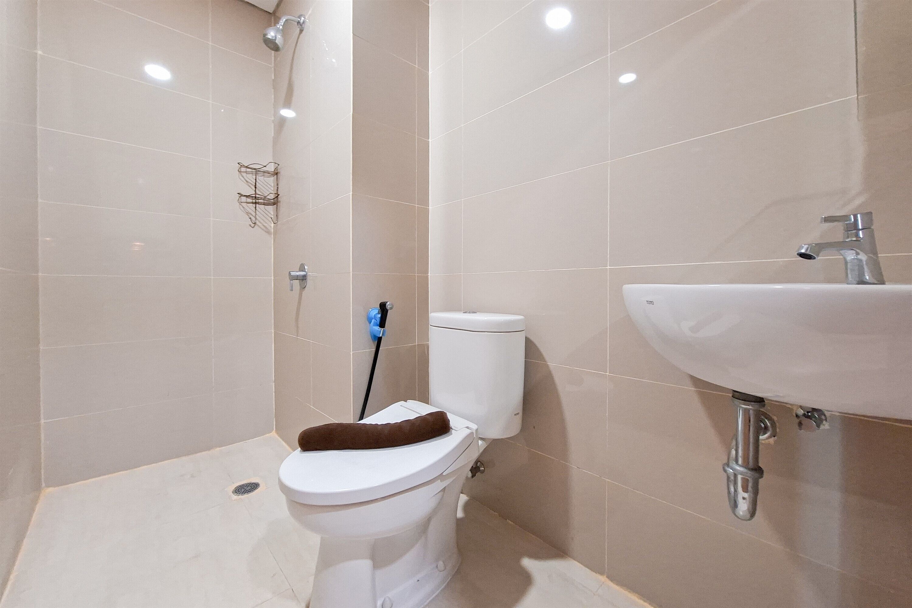 A bathroom with a toilet, a shower, and a sink.