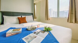 A hotel room with a bed, a window with curtains, and a view of buildings outside. - 2Br Space Near Mall At Bassura City Apartment (Jakarta)