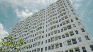 Un immeuble moderne et imposant, doté de nombreux balcons et de grandes fenêtres.