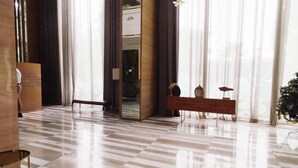 A spacious lobby with a checkered floor, a reception desk, and a bench. - 3Br Near Mall At Grand Sungkono Lagoon Apartment (Surabaya)