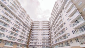 A high-rise residential building with multiple balconies and a central stairwell.
