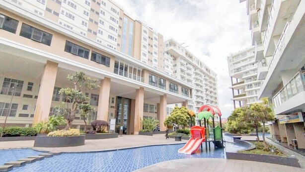 A residential building with a swimming pool and a children's play area.