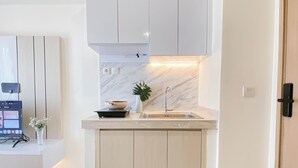 A modern kitchen with a marble backsplash, a built-in sink, and a small countertop.