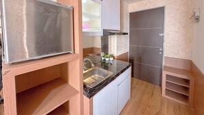 A compact kitchen with a stainless steel refrigerator, a sink, and a microwave. - Minimalist Studio (No Kitchen) At Tamansari Prospero Sidoarjo Apartment (Sidoarjo)