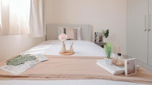 Een keurig opgemaakt slaapkamer met een bed, nachtkastje en een kledingkast.