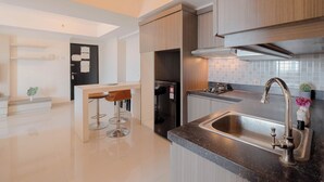 Een moderne keuken met een centraal kookeiland, een RVS spoelbak en houten kastjes.