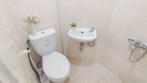 A bathroom with a toilet, sink, and shower. - Studio Minimalist And Warm At Pavilion Permata Apartment (Surabaya)