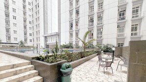 Terraza en la azotea con piscina, mobiliario exterior y un contenedor de basura.