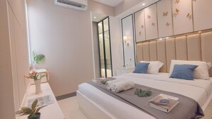 A modern bedroom with a large bed, bedside tables, a mirror, and decorative butterfly wall panels. - Comfort 2Br Direct Access To Mall At Benson Supermall Mansion Apartment (Surabaya)