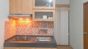 Una cocina funcional con estufa a gas, un lavamanos y armarios de madera.