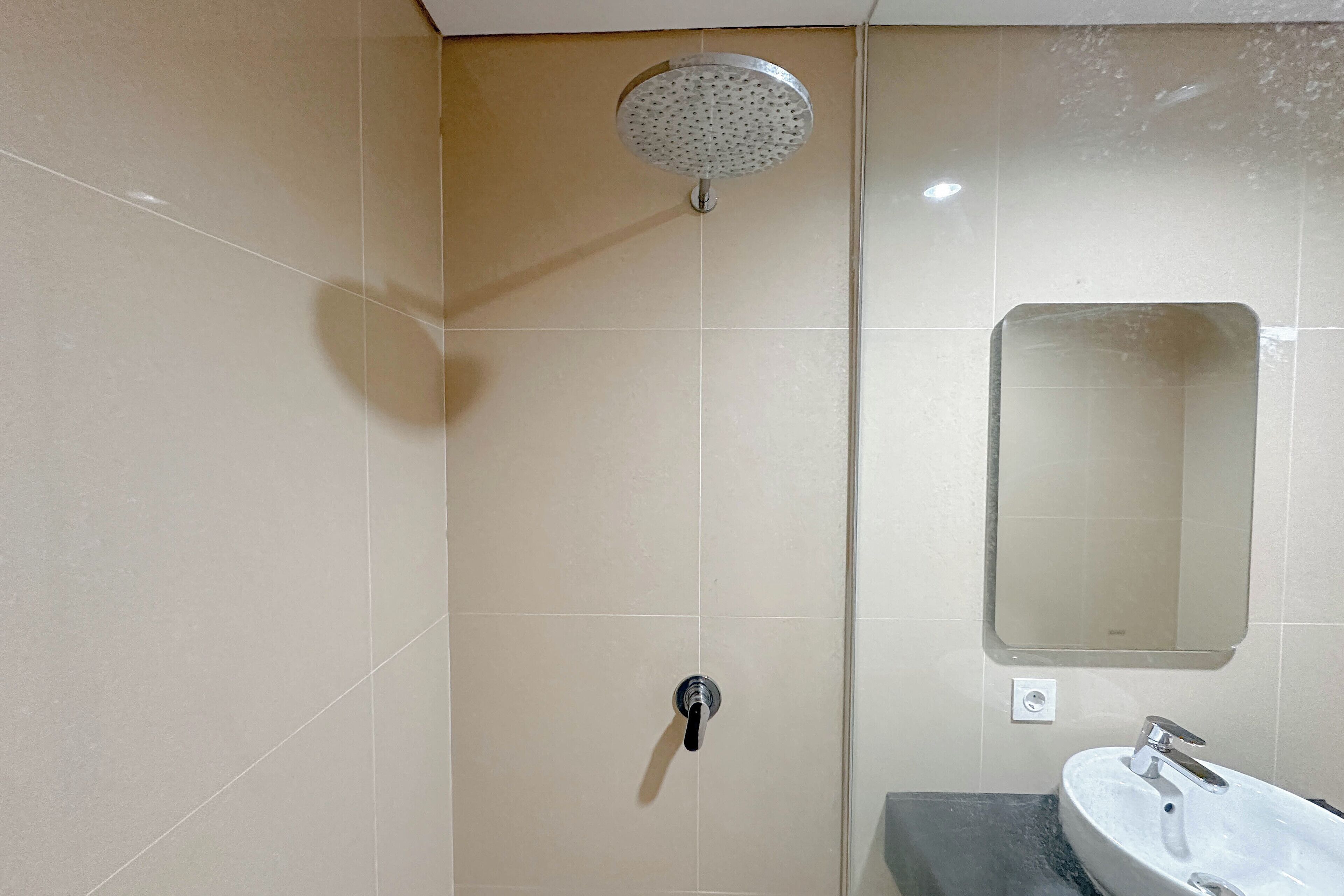 A bathroom with a shower, sink, and mirror.