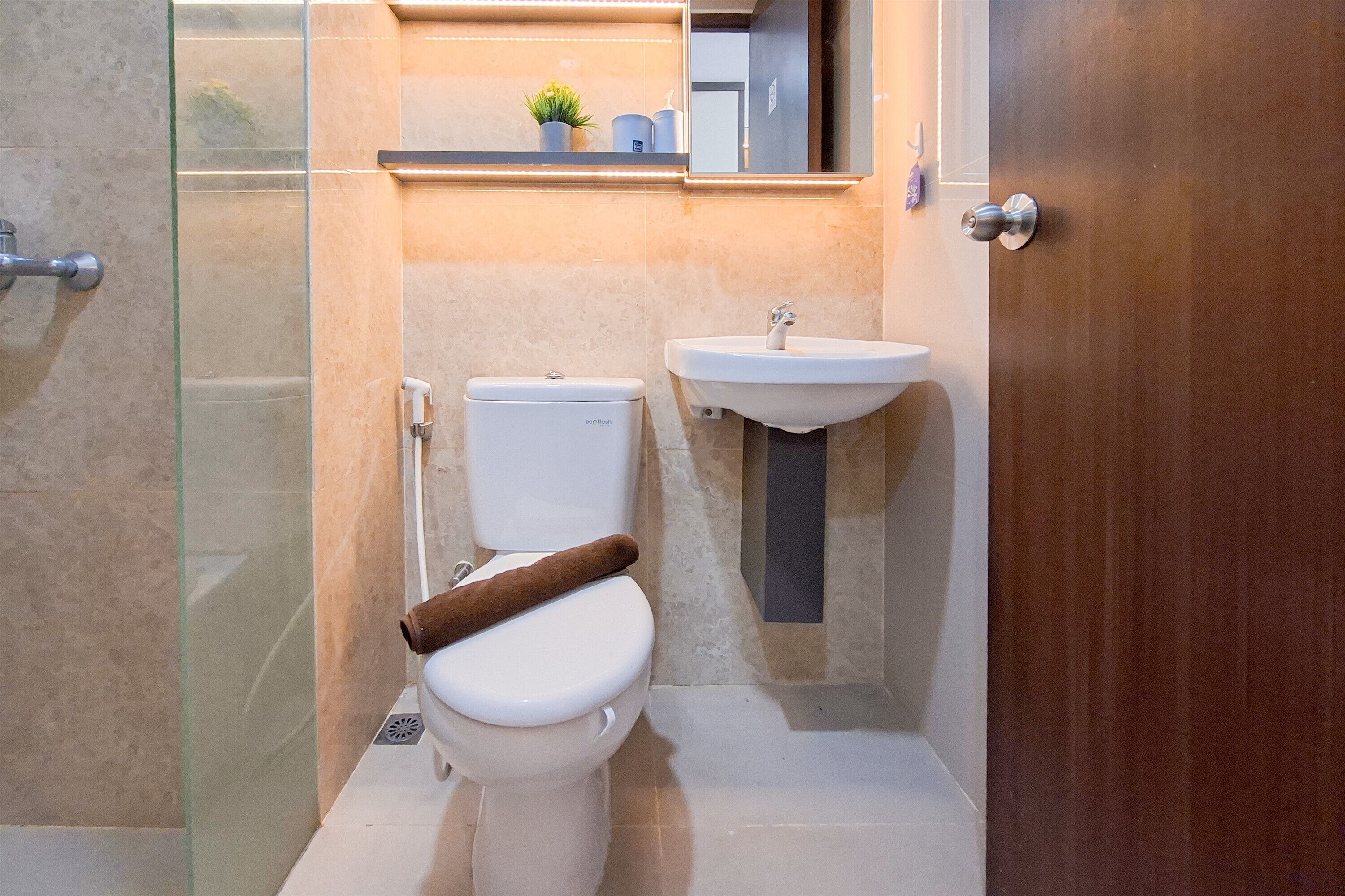 A bathroom with a toilet, a sink, and a glass shower enclosure.