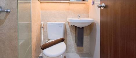 A bathroom with a toilet, a sink, and a glass shower enclosure.