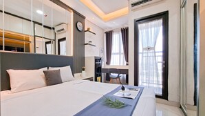 Une chambre d’hôtel moderne, dotée d’un grand lit, d’un bureau et d’une fenêtre avec des rideaux.