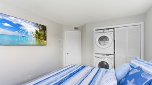 Ein Schlafzimmer mit einem Bett, einer Waschmaschine und einer Tür.