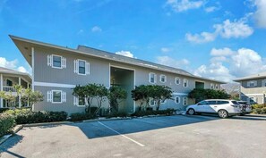 A multi-story residential building with a parking lot in front. - 30A Cozy Getaway - Steps to Sand! (Santa Rosa Beach)