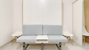 A modern room with a grey sofa, white chairs, and a white wardrobe. - Studio (No Kitchen) Apartment At Bandaraya - Tallasa City Makassar Near Unhas (Makassar)