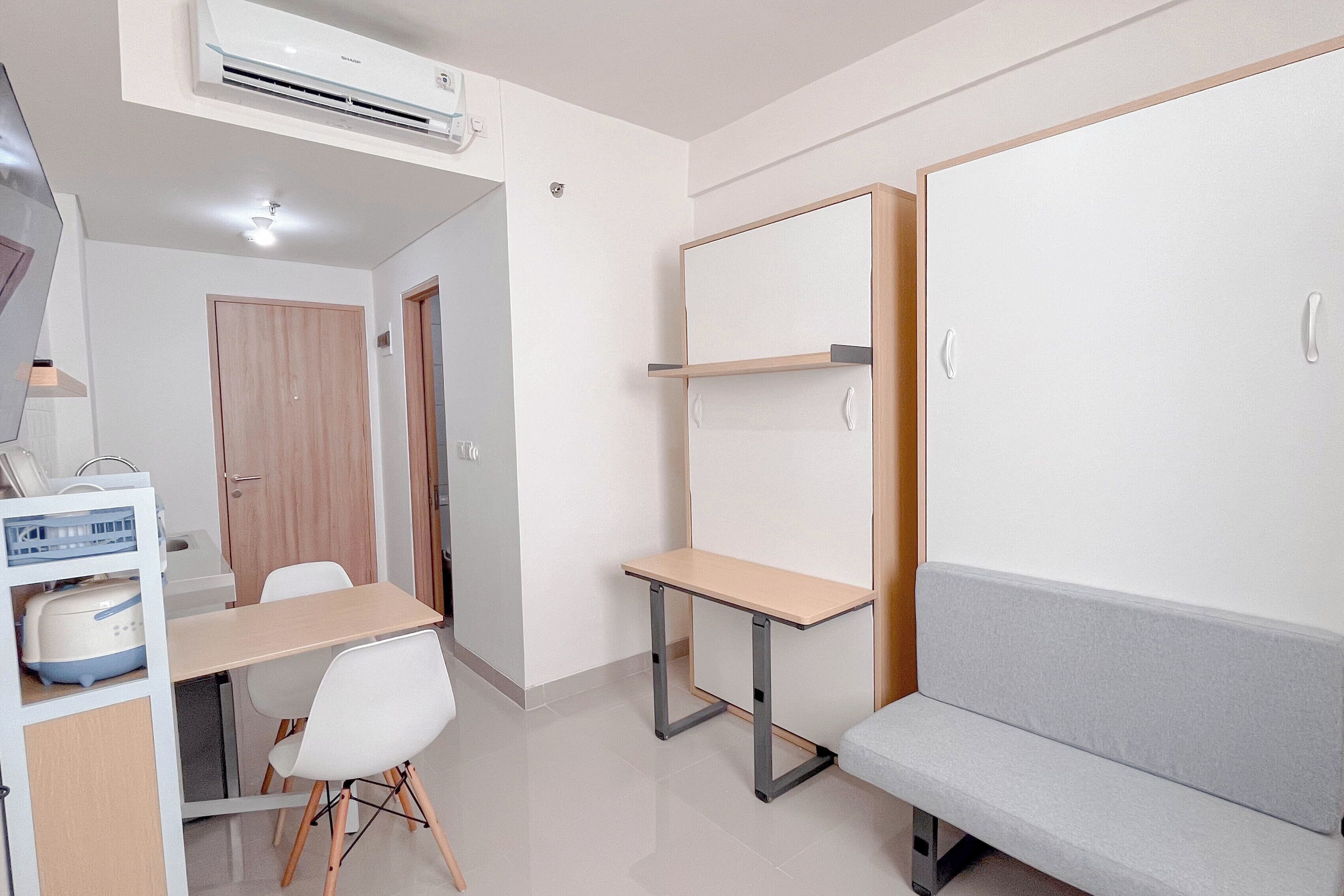 A compact room with a desk, a chair, a bench, and a wardrobe.