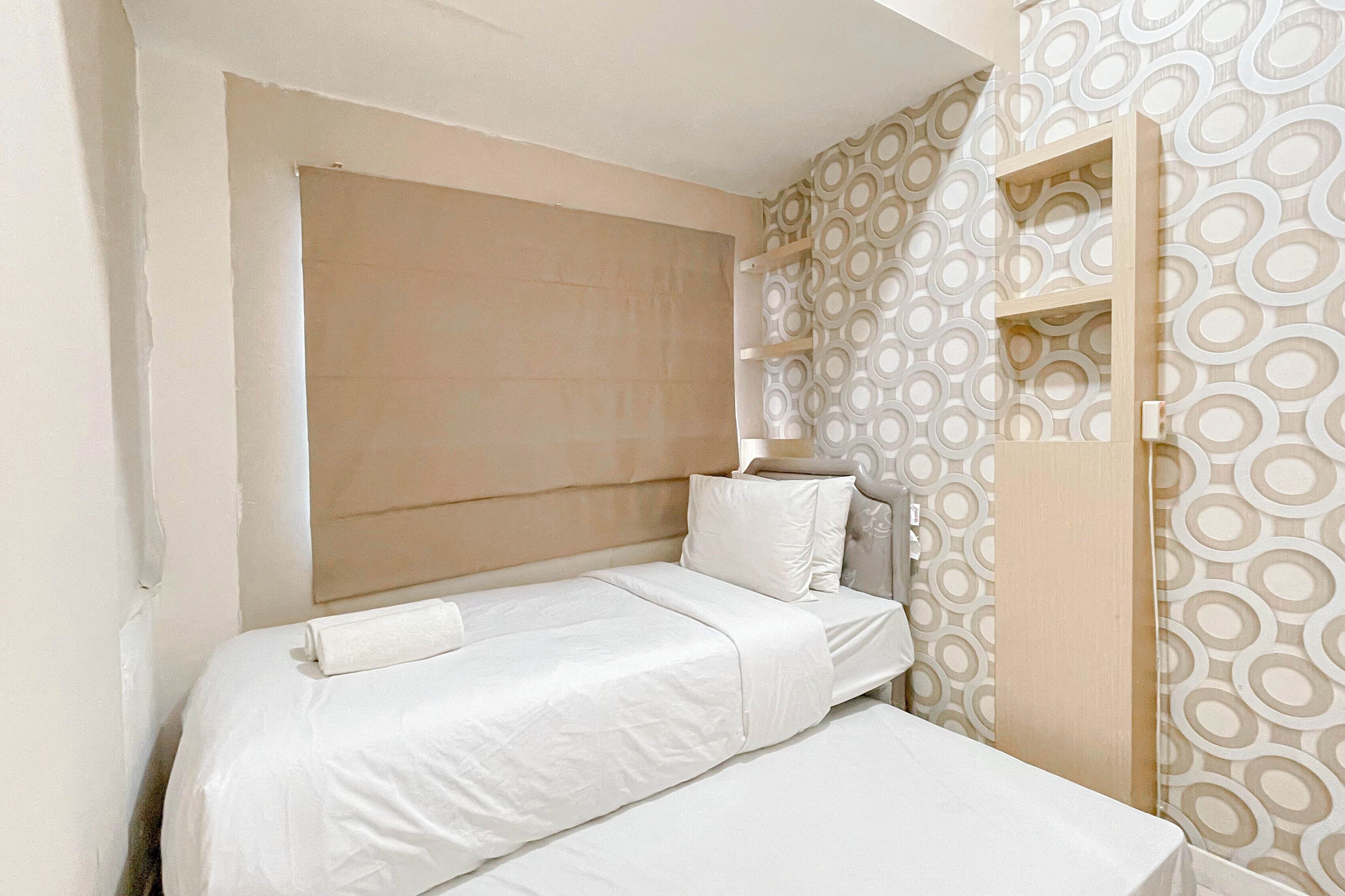 Un dormitorio pequeño y ordenado con una cama individual, una mesita de noche y un armario.
