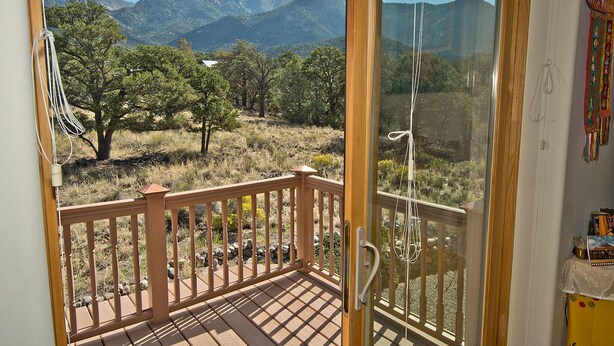 A balcony with a view of mountains and trees. - White Lotus House - 2 BR, 2.5 Bath Luxury Sanctuary in Crestone, Colorado (Crestone)