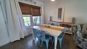 A dining area with a table and chairs, a bookshelf, and a framed picture on the wall. - Adorable house with a large private back yard in sunny Vero Beach (Vero Beach)
