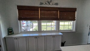 A kitchen with a window, white cabinets, and a door. - Adorable house with a large private back yard in sunny Vero Beach (Vero Beach)