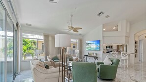 A spacious living room with a sofa, armchairs, a coffee table, and a TV. - Ft. Myers Beach Escape | Pool + Canal Views (Fort Myers Beach)