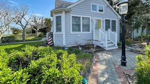 A small, single-story house with a front porch, a mailbox, and a street lamp. - Pet Friendly 4 Bedroom Just Steps to Beach (Cape May Point)