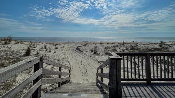 A wooden staircase leading to a beach with a clear sky. - Pet Friendly 4 Bedroom Just Steps to Beach (Cape May Point)