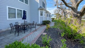 A residential house with a patio, outdoor furniture, and a tree. - Pet Friendly 4 Bedroom Just Steps to Beach (Cape May Point)