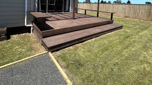 Une maison dotée d’une terrasse en bois et d’un patio couvert.