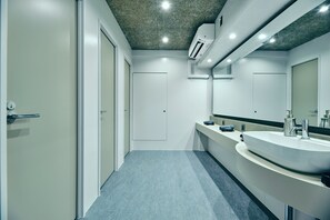 Un bagno moderno con un lavandino ampio, uno specchio e una porta.