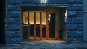 A building entrance with a URO sign above a wooden door with glass panels. - HOTEL URO - hostel (Nagasaki)