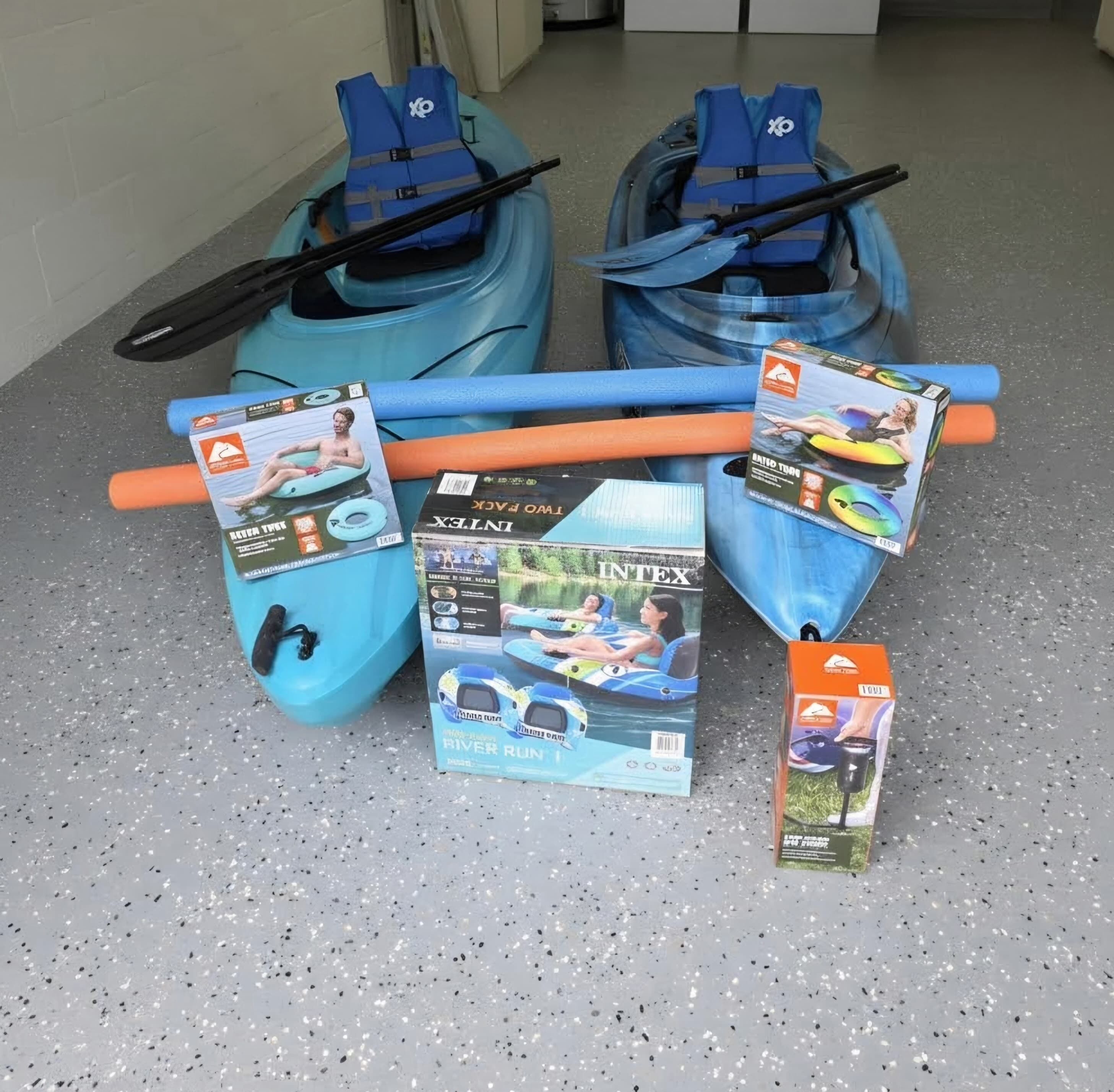 Two kayaks, a paddle, and several water sport equipment boxes.