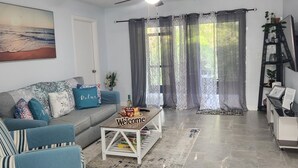 Un salon avec un canapé, une table basse et un ventilateur de plafond.