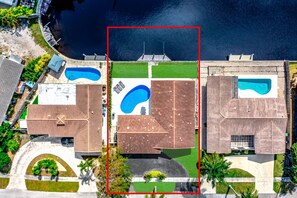 An aerial view of a residential area with multiple swimming pools, a large central lawn, and surrounding houses. - Heated Pool+Waterfront! Close 2 Beach+Restaurants! (Fort Lauderdale)