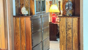 Une porte en bois avec un miroir, une lampe rouge et une statuette décorative en forme de hibou.