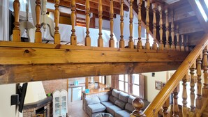 A wooden staircase with a view of a living room below, including a sofa and a fireplace. - El Rincón de Soto - Covadonga and Cangas de Onís (Cangas De Onis)