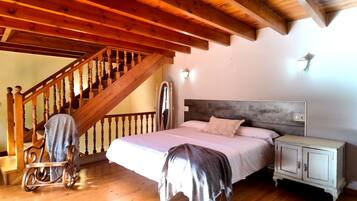 Ein Schlafzimmer mit einer Holztreppe, einem Bett mit Kopfteil, einem Nachttisch und einem Kleiderschrank.