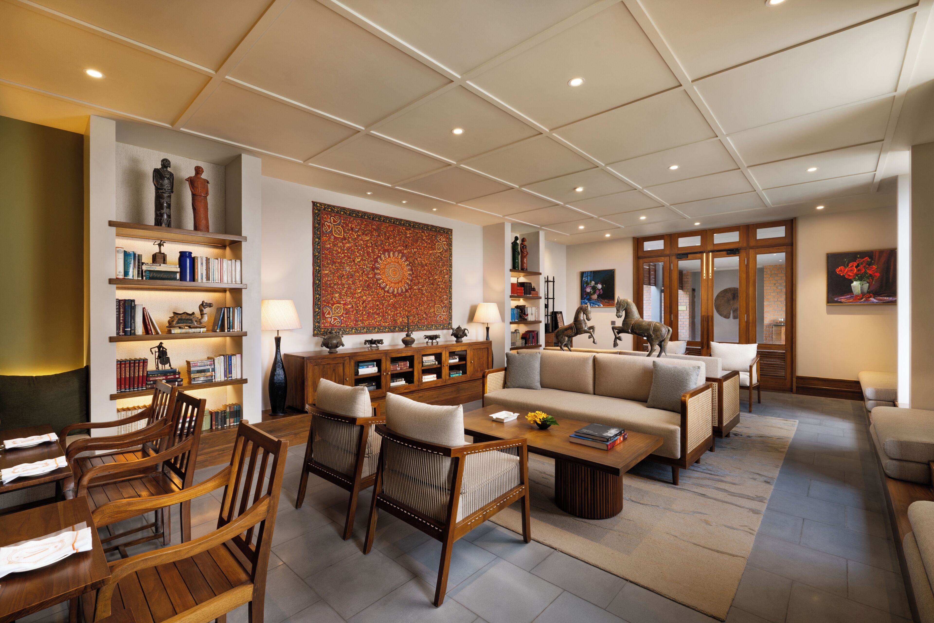 A spacious living room with a sofa, chairs, a coffee table, and a bookshelf.
