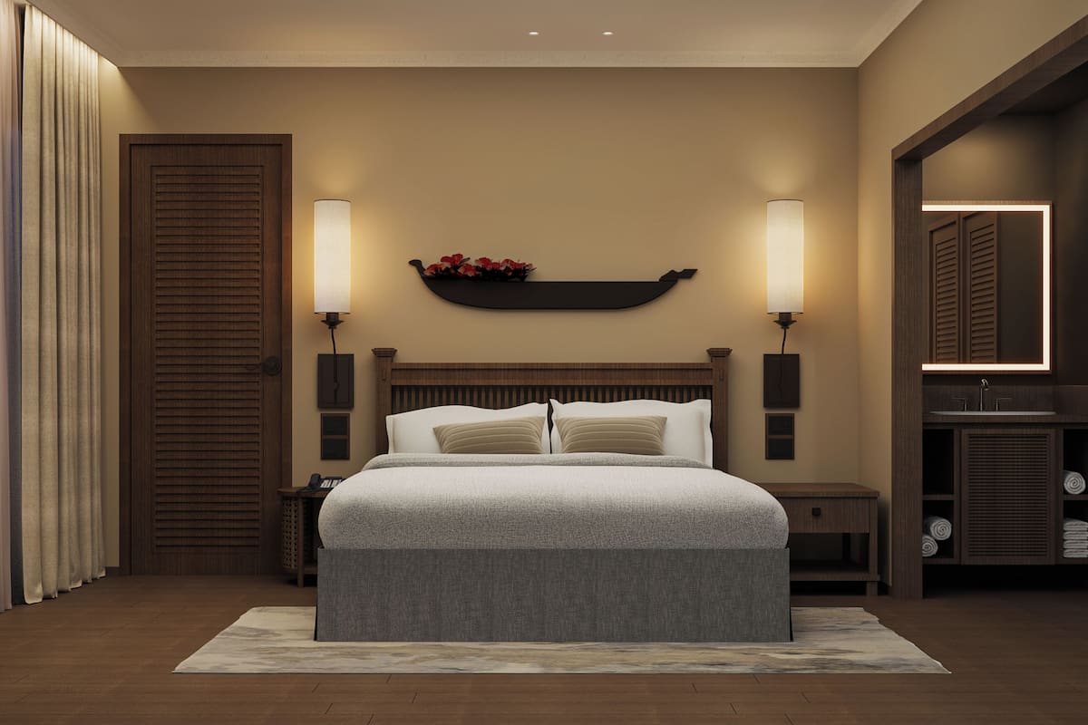 Quarto com cama, duas mesas de cabeceira, um criado-mudo, prateleira na parede com flores e espelho com iluminação.
