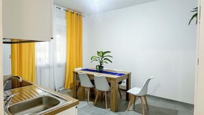 A compact kitchen with a sink, a dining table with chairs, and a potted plant. - aMare Apartment, cozy accommodation a few steps from the sea (Nettuno)