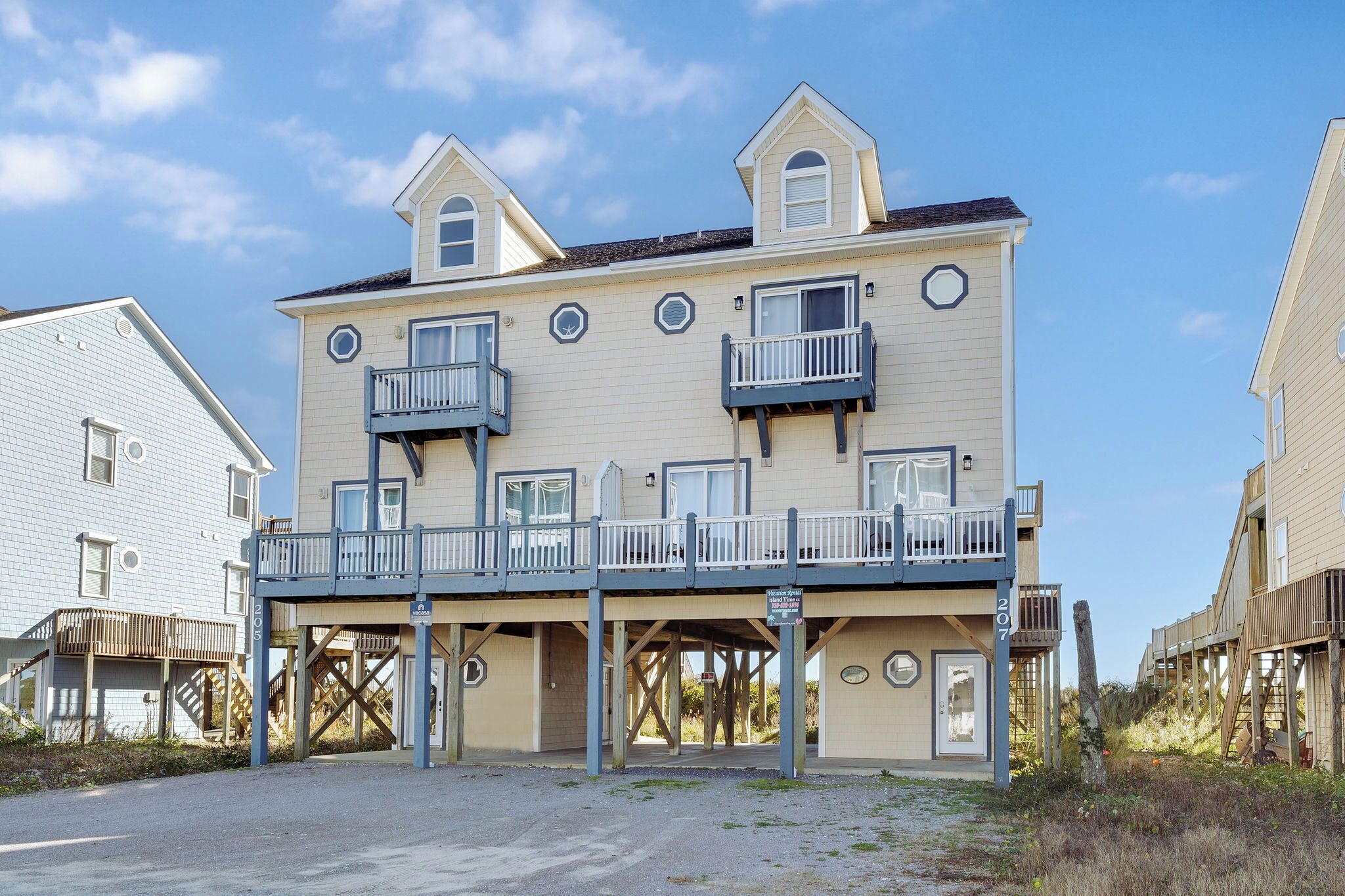 A multi-story building with balconies, a covered walkway, and a beachside location.