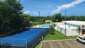A modern building with a swimming pool, a covered area, and a parking lot. - Enjoy in Charming Place, 3-bedroom, 2 bathroom with AC in Río Grande (Río Grande)