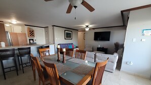 A dining area with a glass table, wooden chairs, and a ceiling fan. - Enjoy in Charming Place, 3-bedroom, 2 bathroom with AC in Río Grande (Río Grande)