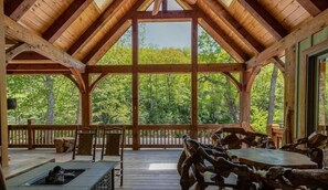 A wooden pavilion with a high ceiling and large windows overlooking a forest. - River Rock Retreat on the River (Burnsville)