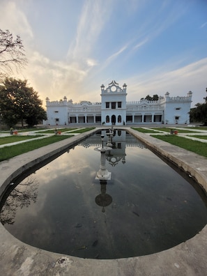 A large white building with a central fountain and symmetrical garden layout. - Amã Stays & Trails Anand Bhawan Palace, Kannauj (Tirwa)