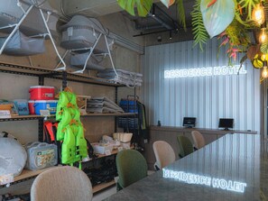 A room with a desk, chairs, and a neon sign reading "RESIDENCE HOTEL". - Meer ResidenceHotel MiyakoAirport (Miyakojima)
